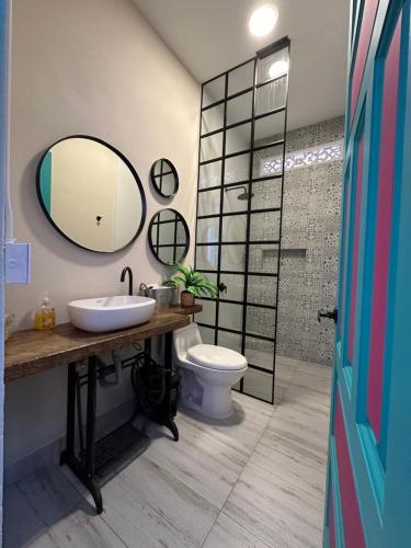 a bathroom with a sink and a toilet and a mirror at CASA HOTEL LAS HORTENSIAS in Jardin