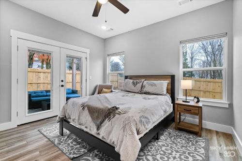 a bedroom with a bed and a chair and windows at Central Getaway Off of I-49 in Springdale