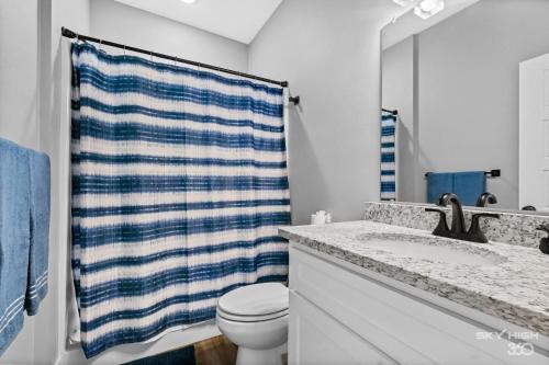 a bathroom with a toilet and a blue and white towel at Central Getaway Off of I-49 in Springdale