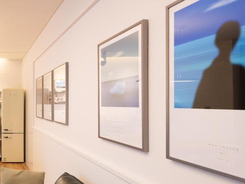 a hallway with three framed photographs on a wall at Boutique Pool Villa NAMIB in Jeju