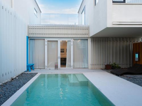 a swimming pool in the courtyard of a house at Boutique Pool Villa NAMIB in Jeju