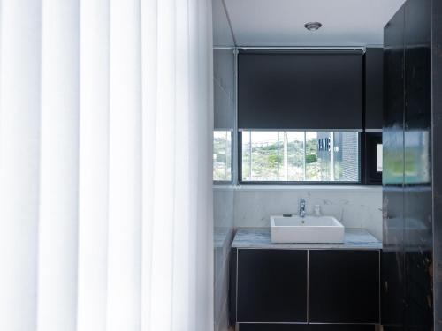a bathroom with a sink and a window at Boutique Pool Villa NAMIB in Jeju