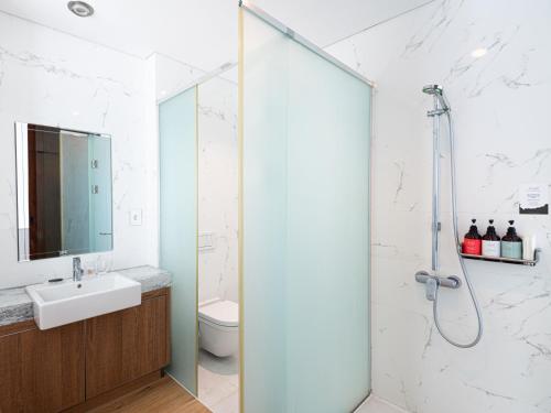 a bathroom with a shower and a sink at Boutique Pool Villa NAMIB in Jeju