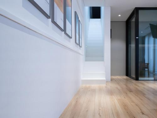 a hallway of a house with white walls and wooden floors at Boutique Pool Villa NAMIB in Jeju