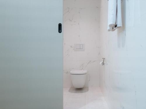 a white bathroom with a toilet and a shower at Boutique Pool Villa NAMIB in Jeju