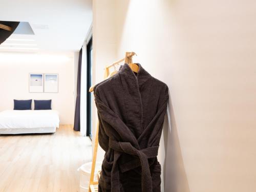 a robe hanging on a rack in a room at Boutique Pool Villa NAMIB in Jeju