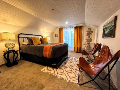 a bedroom with a bed and chairs in a room at Sea Glass Inn in Seaside