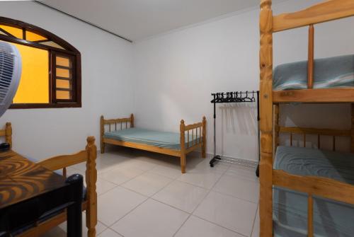 a room with three bunk beds and a window at Casa Temporada em Caraguá in Caraguatatuba