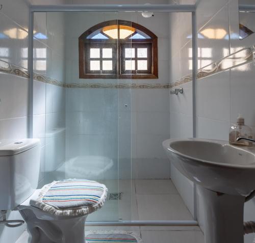 a bathroom with a sink and a toilet and a shower at Casa Temporada em Caraguá in Caraguatatuba