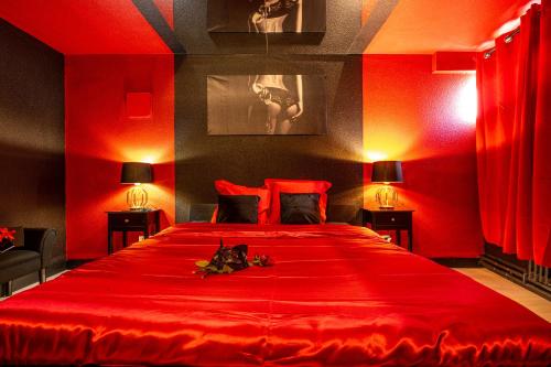 a red bedroom with a large red bed with two lamps at Cocon Sensuel - 50 Nuances - Les Cocons de Nath in Montbéliard