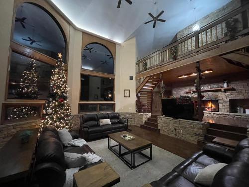 a living room with a christmas tree and a fireplace at Crestview Estate 5 acres-heated pool-5min to strip in Pigeon Forge
