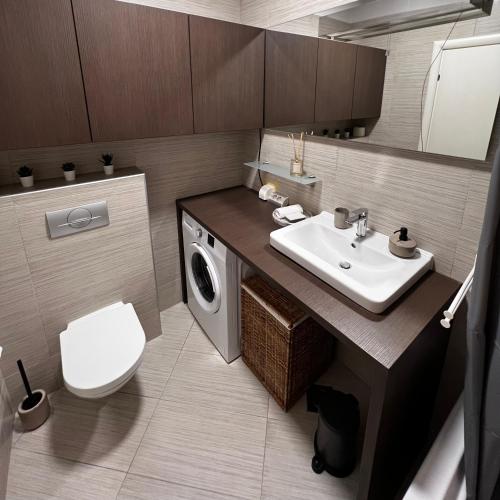 Un baño con lavabo y lavadora. en Maestral Living Studio Apartment, en Zagreb