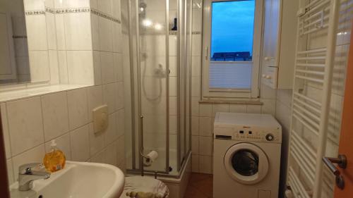 uma casa de banho com um lavatório e uma máquina de lavar roupa em Ostseeerlebnis em Graal-Müritz