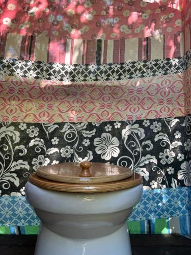 a white toilet with a wooden seat in a bathroom at Planta Farm - Jungle Stay in Santa Maria Huatulco