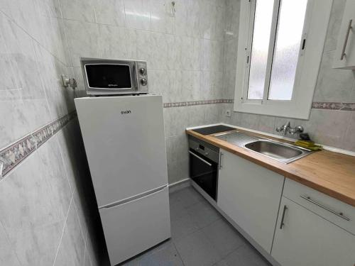 a small kitchen with a microwave on top of a refrigerator at Centrally Apartment in el Raval Neighbourhood in Barcelona