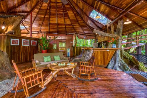 a living room of a tree house with a table and chairs at Tree House Lodge in Puerto Viejo