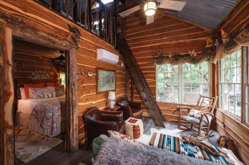 una camera con un letto in una baita di tronchi di Hobbit Treehouse with waterfall on the Brazos River! 350 acres! Tubing! Petting zoo! a Weatherford