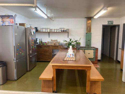 een keuken met een houten tafel en een koelkast bij Wedderburn Farm Stay in Wedderburn