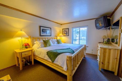 1 dormitorio con cama de madera y TV en Tree House, en Brian Head