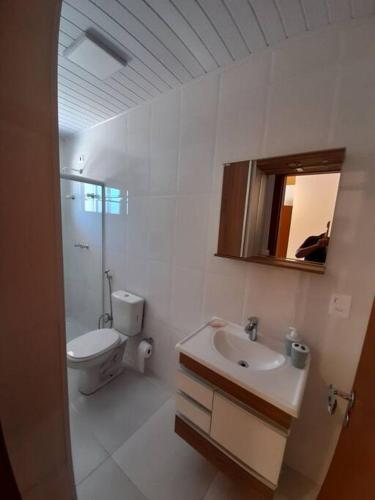 La salle de bains blanche est pourvue de toilettes et d'un lavabo. dans l'établissement Seu Refúgio na Montanha Magnífica, à Santo Antônio do Pinhal