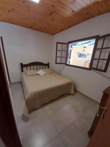 una piccola camera con letto e finestra di Seu Refúgio na Montanha Magnífica a Santo Antônio do Pinhal