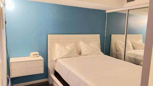 1 dormitorio con 1 cama con pared azul en A lovely - 1 bedroom condo with swimming pool, en Toronto