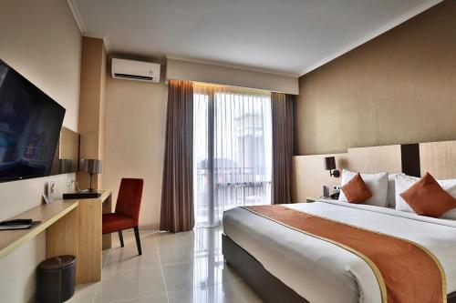 um quarto de hotel com uma cama e uma grande janela em Riss Hotel Malioboro em Yogyakarta