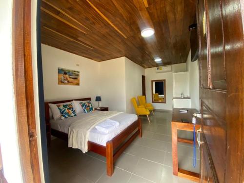 um quarto com uma cama e um tecto em madeira em Hotel Candy Rose em Colón