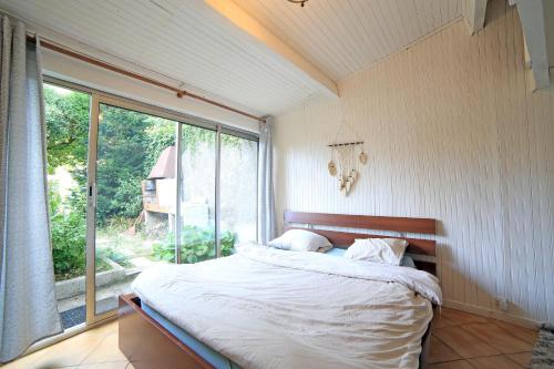 a bedroom with a bed and a large window at Chambre 4, calme, 1 station de PARIS in Maisons-Alfort