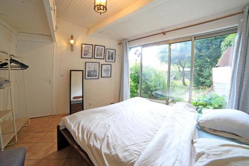 a bedroom with a bed and a large window at Chambre 4, calme, 1 station de PARIS in Maisons-Alfort