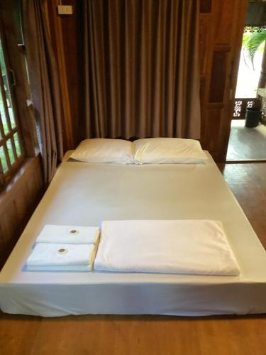 two beds in a room with white sheets and pillows at Oh taley resort in Rayong