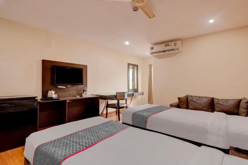 a hotel room with two beds and a flat screen tv at Udayee International Hotel in Tirupati