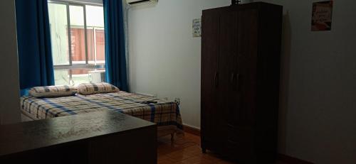 a small bedroom with a bed and a window at Kitnet Mobiliada no centro de São Leopoldo. in São Leopoldo