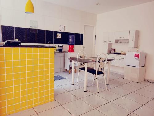 eine Küche mit einem Tisch und Stühlen in der Unterkunft Apê Térreo, próximo ao Shopping! in Petrolina