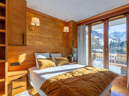 une chambre avec un lit et une grande fenêtre dans l'établissement Appartement de charme avec wifi, balcon et vue village - FR-1-694-128, à Val dʼIsère