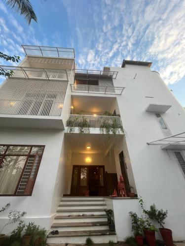 a white house with stairs in front of it at NIRVANA HAVEN HOME STAY in Trivandrum