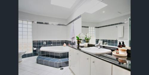 a bathroom with two sinks and a bath tub at Water Front House in Sydney