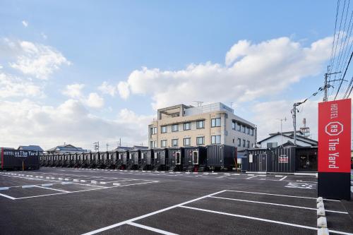a parking lot with a large white building at HOTEL R9 The Yard 長浜 in Nagahama