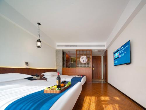 a hotel room with two beds and a flat screen tv at Riverside Peak Lodge Zhangjiajie Wulingyuan National Park in Zhangjiajie