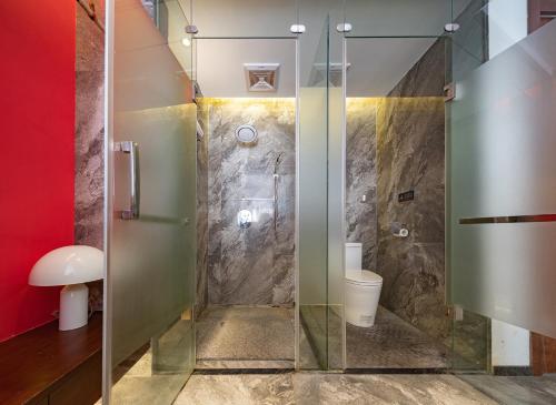 a bathroom with a glass shower with a toilet at Riverside Peak Lodge Zhangjiajie Wulingyuan National Park in Zhangjiajie
