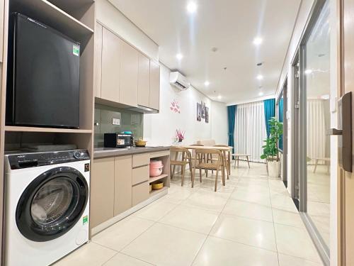 een keuken en een woonkamer met een wasmachine bij The Song VT Beach Apartment in Vung Tau