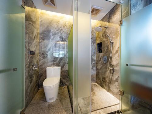a bathroom with a toilet and a shower at Riverside Peak Lodge Zhangjiajie Wulingyuan National Park in Zhangjiajie