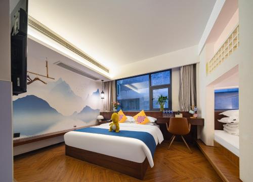 张家界Riverside Peak Lodge Zhangjiajie Wulingyuan National Park的一间卧室，里面有一张大床，床上有一只泰迪熊
