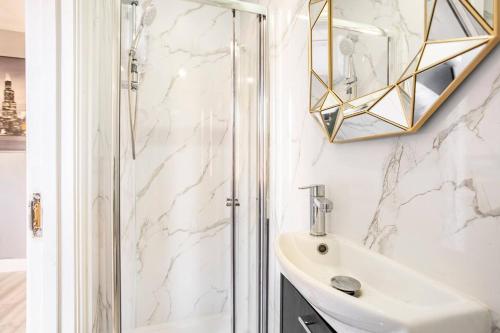 a bathroom with a sink and a shower at Victorian Style Apartment w/ Four-Poster Bed in Camden Town in London