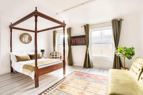a bedroom with a canopy bed and a rug at Victorian Style Apartment w/ Four-Poster Bed in Camden Town in London