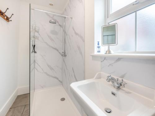 a white bathroom with a sink and a shower at The Gatehouse in East Ferry