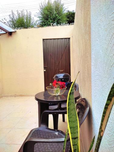 a table with a bowl of flowers on a patio at CASA CIELO Hermosa casa cerca al centro de Paipa in Paipa