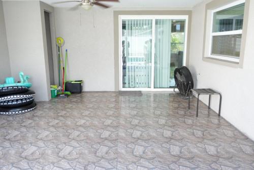 a living room with a stone floor and a sliding glass door at Hosting 1 in Tampa