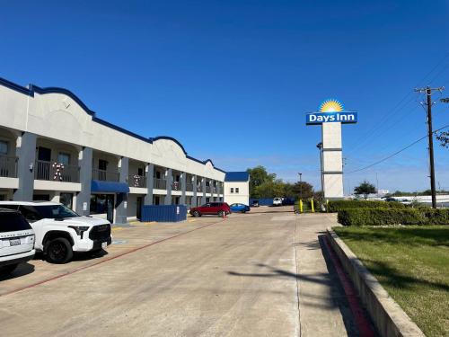 a parking lot in front of a dds inn sign at Days Inn by Wyndham Temple in Temple