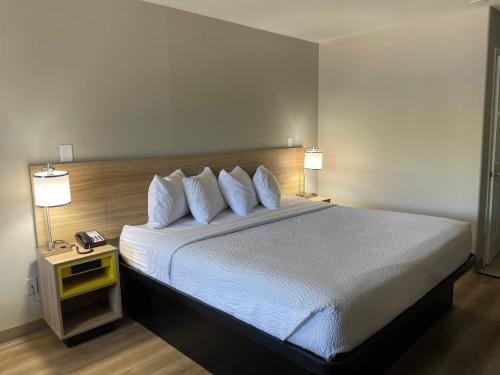 a bedroom with a large bed with white sheets and pillows at Days Inn by Wyndham Temple in Temple